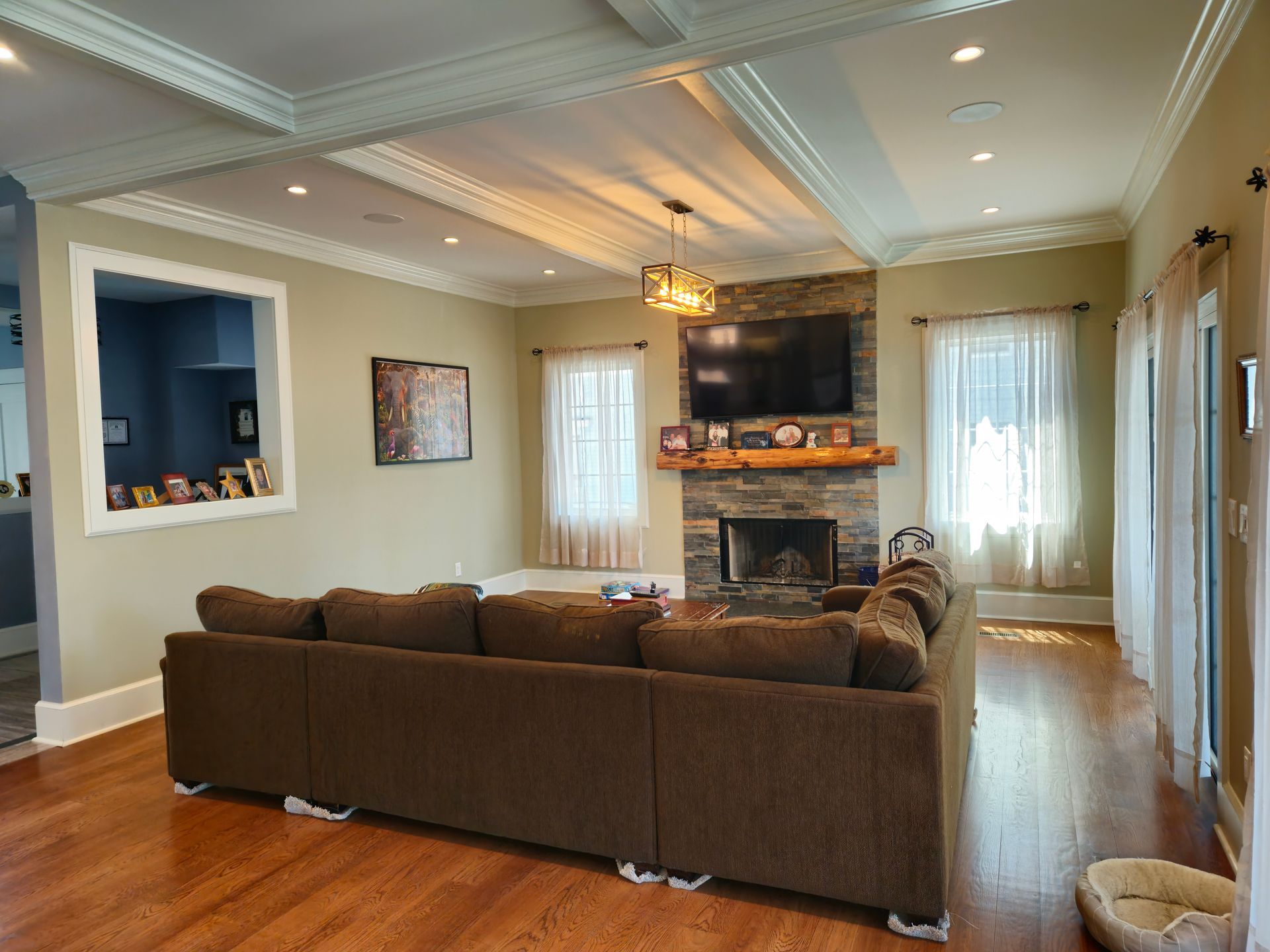 A living room with a couch, fireplace and television.