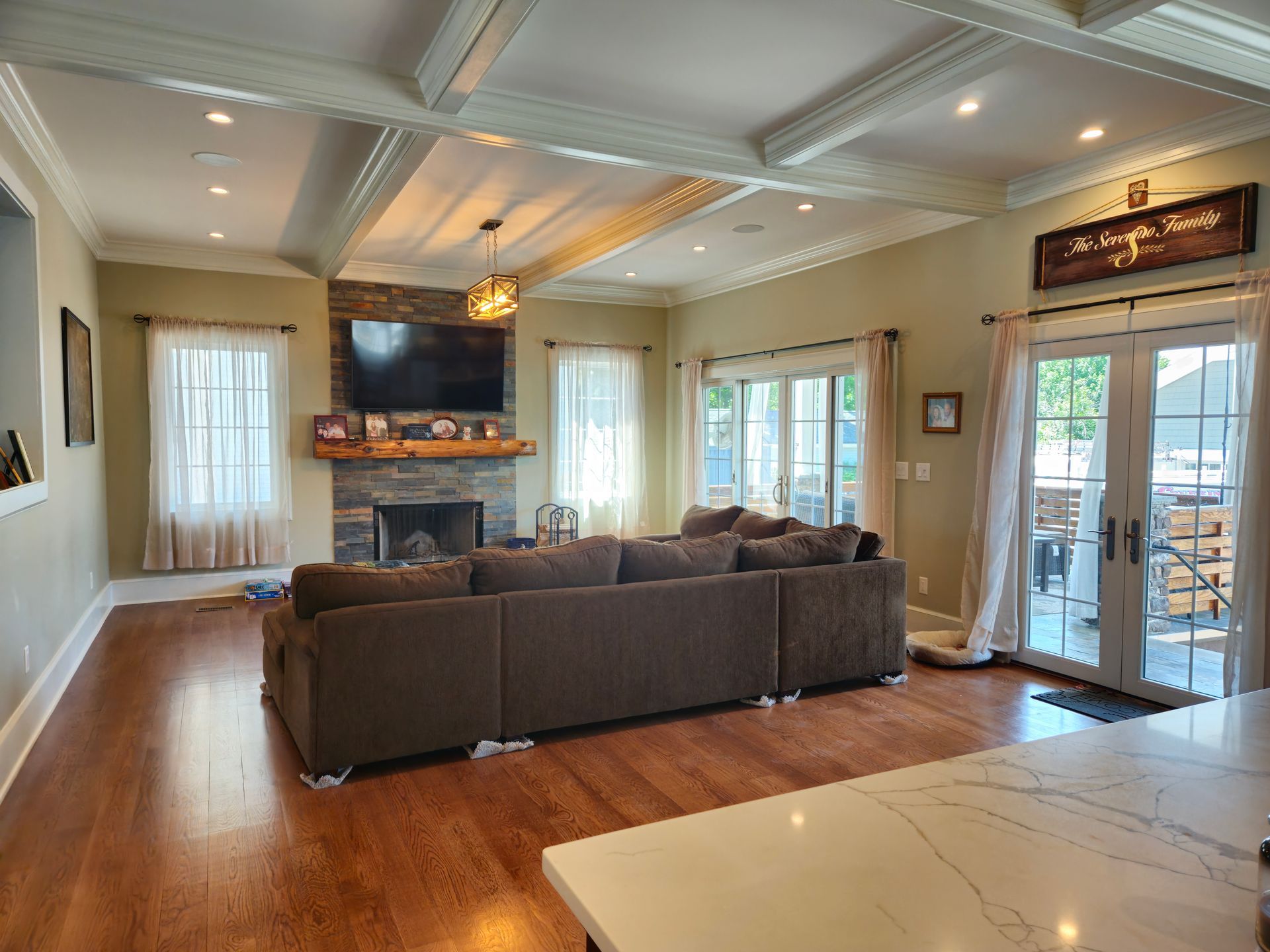 A living room with a couch, fireplace and television.