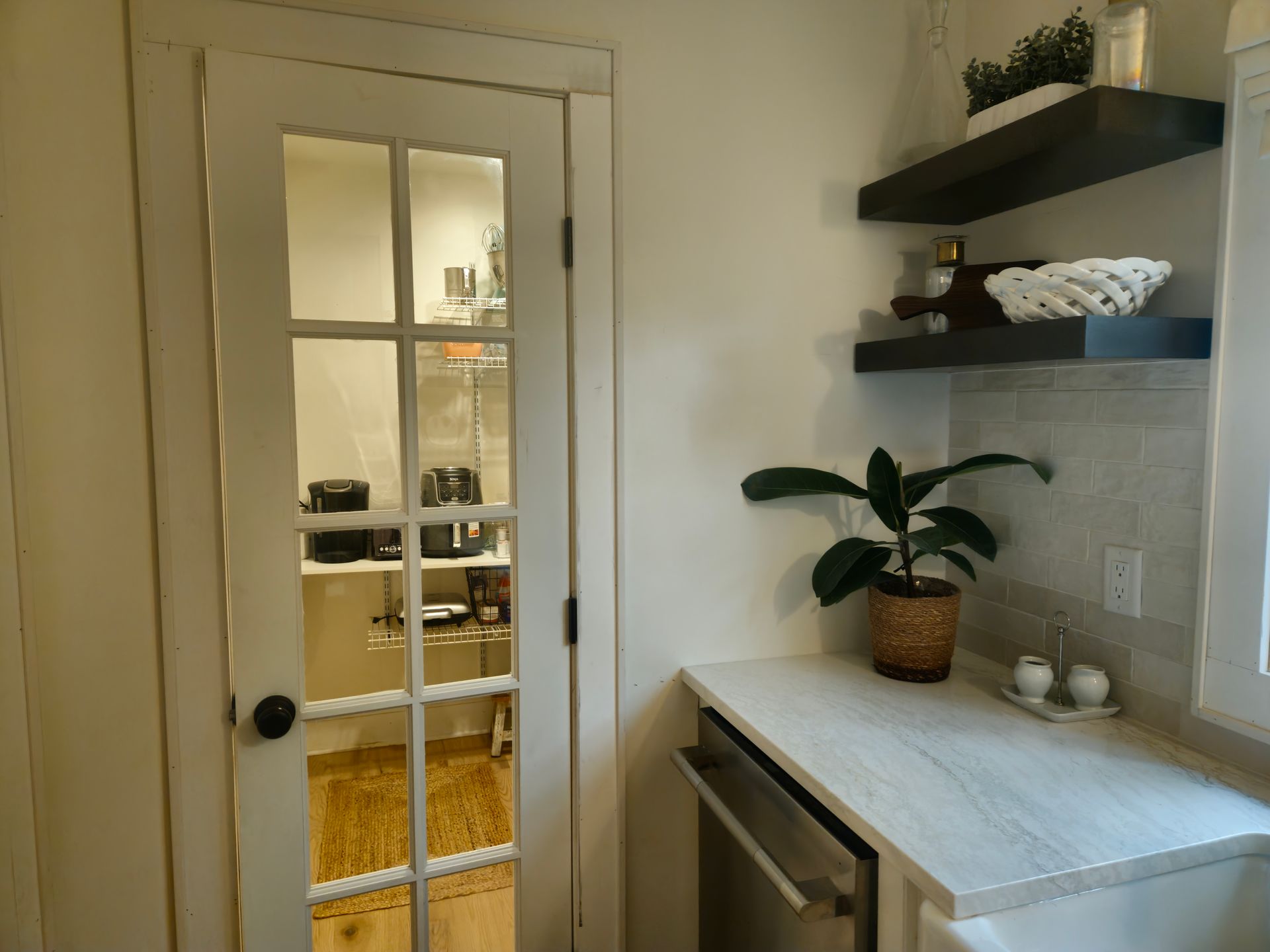 A kitchen with a french door and a plant on the counter