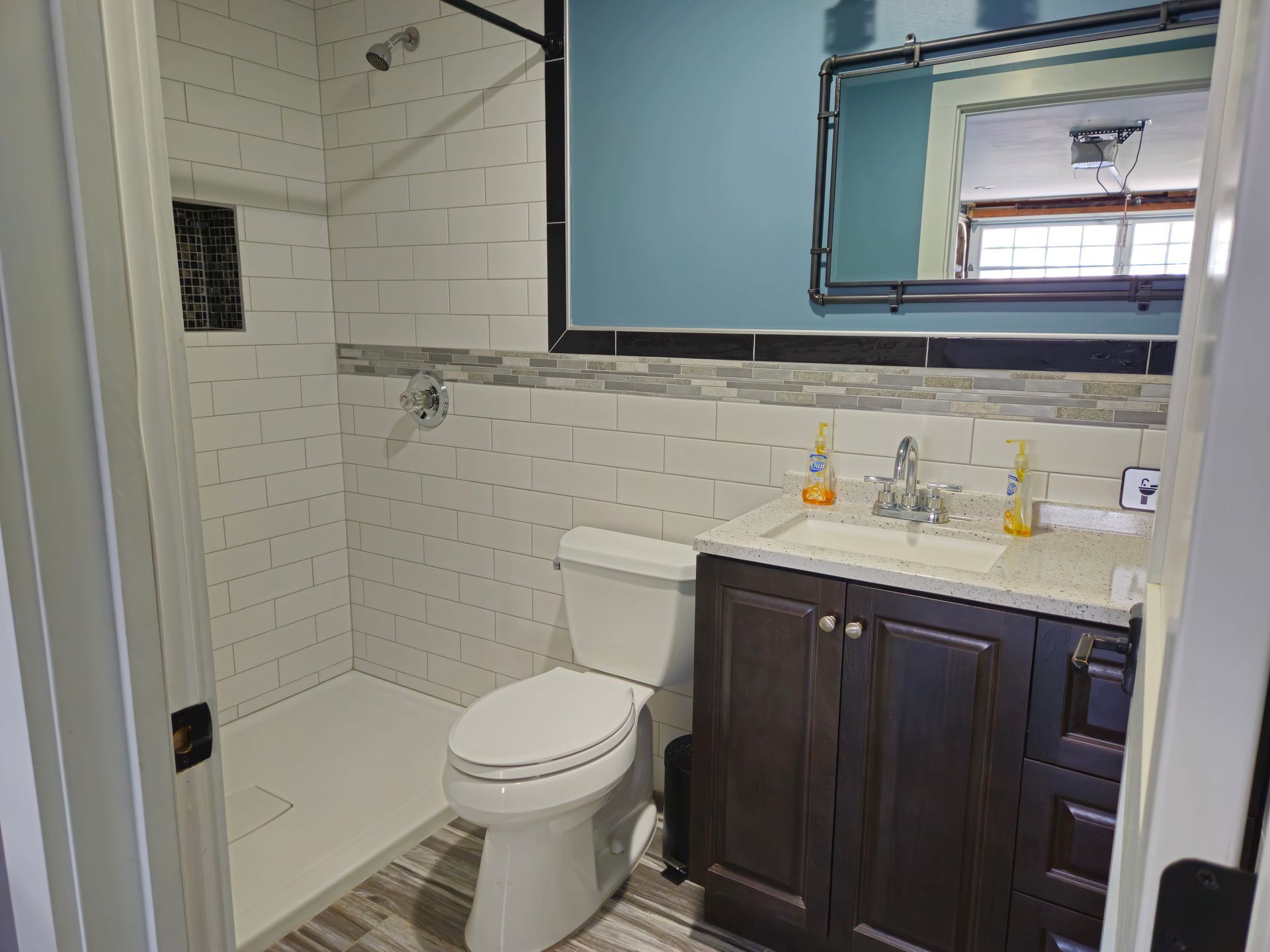A bathroom with a toilet, sink and shower.