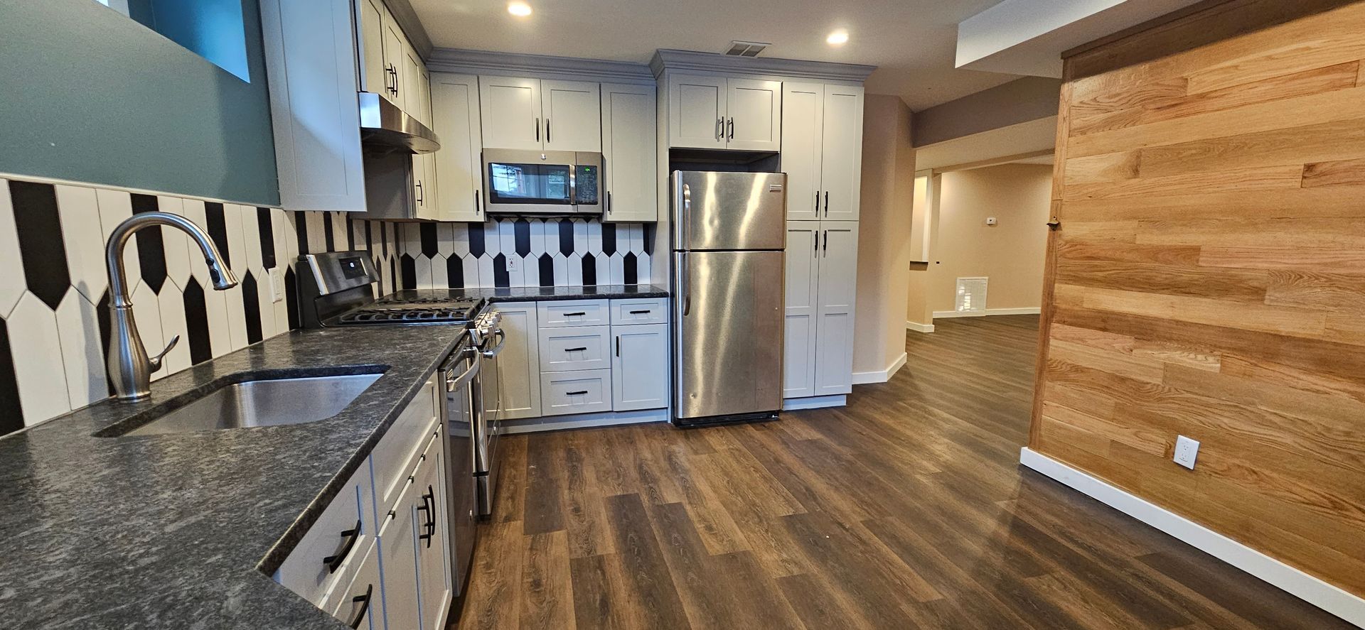 A kitchen with stainless steel appliances and granite counter tops.
