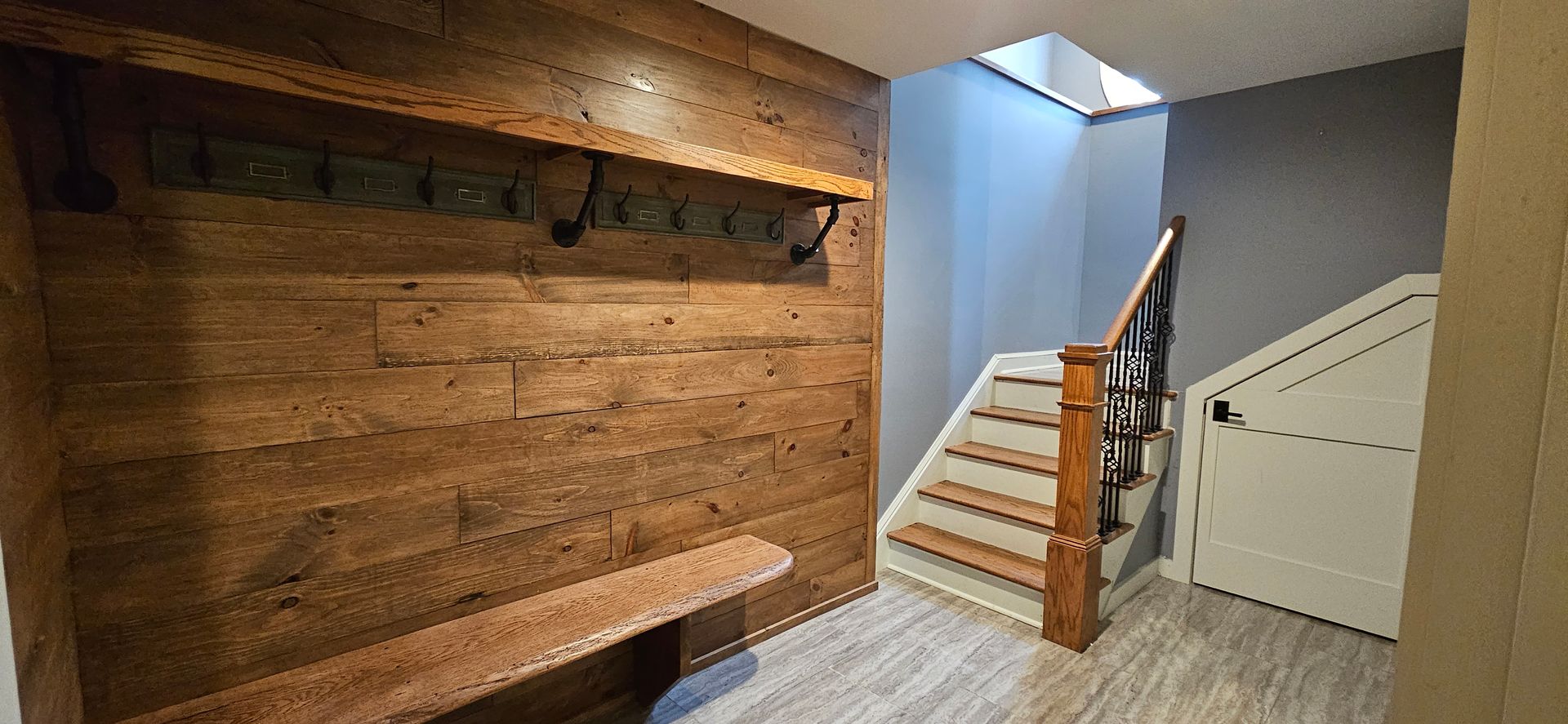 A hallway with a wooden wall and stairs.
