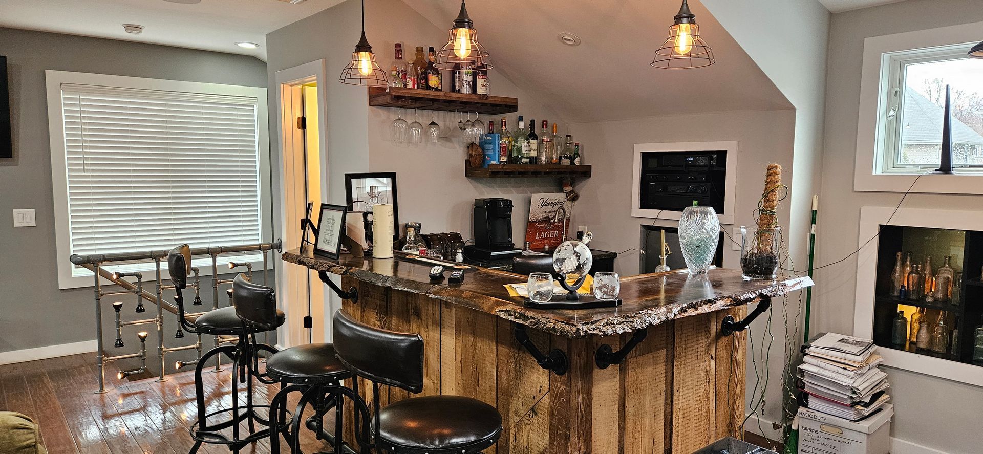 A living room with a wooden bar and stools.