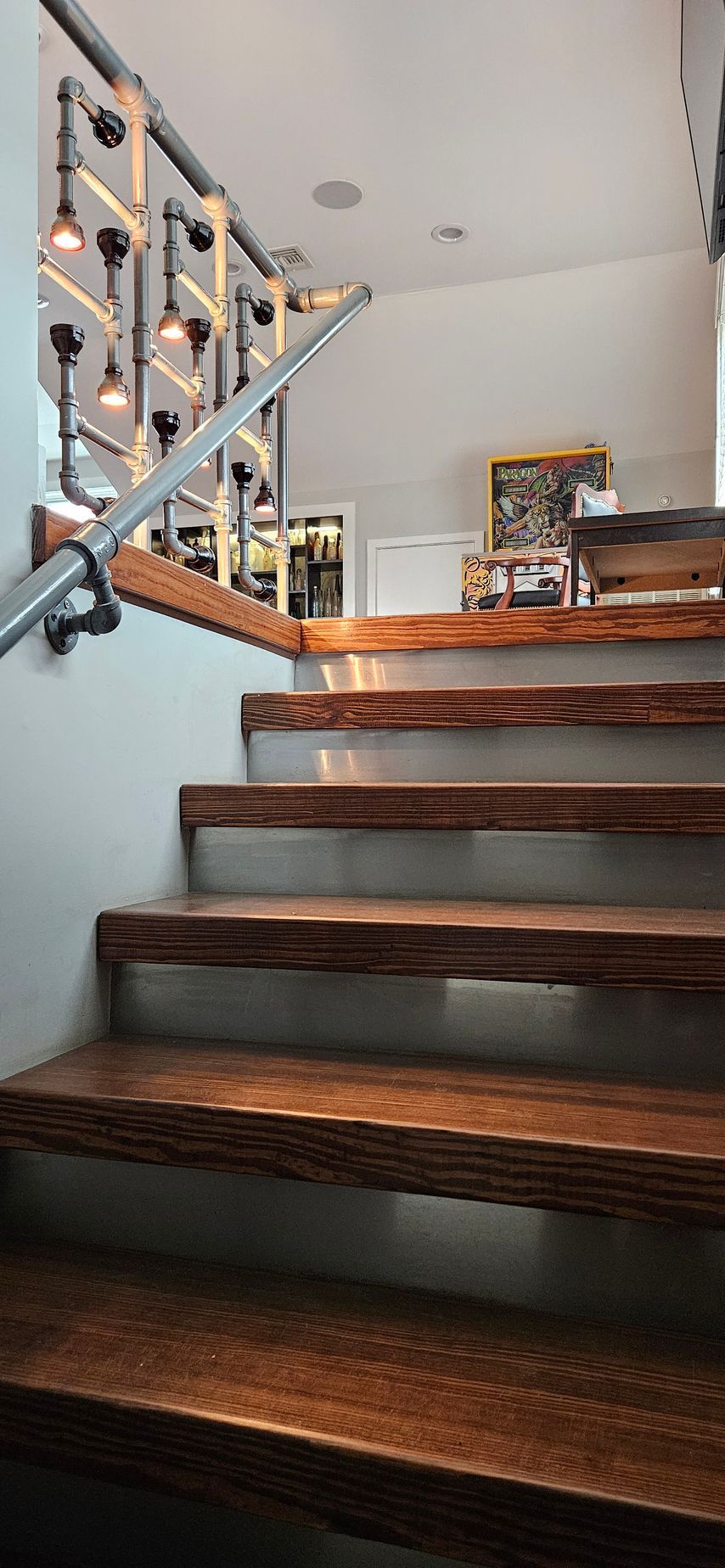 A wooden staircase with a metal railing in a room.