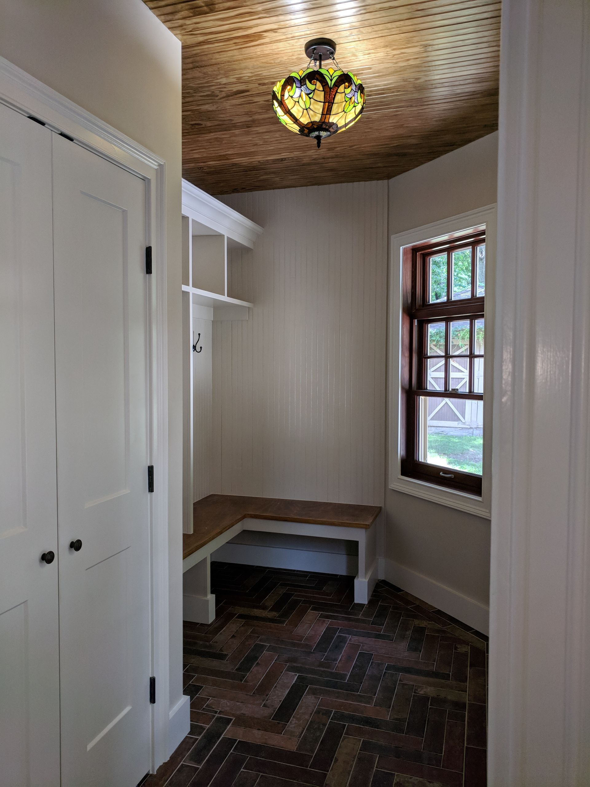 A hallway with a bench and a light on the ceiling