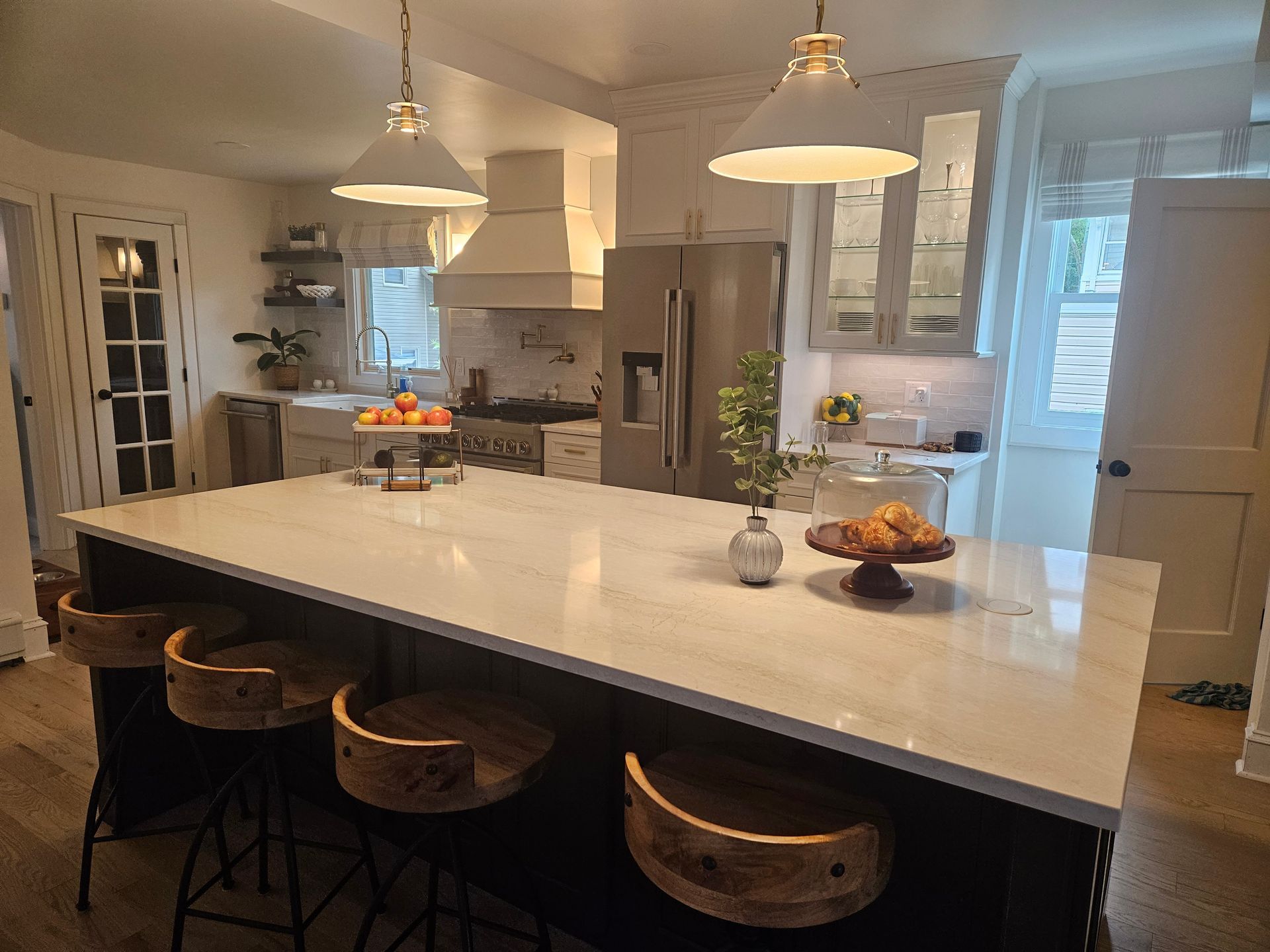 There is a large island in the middle of the kitchen with stools.