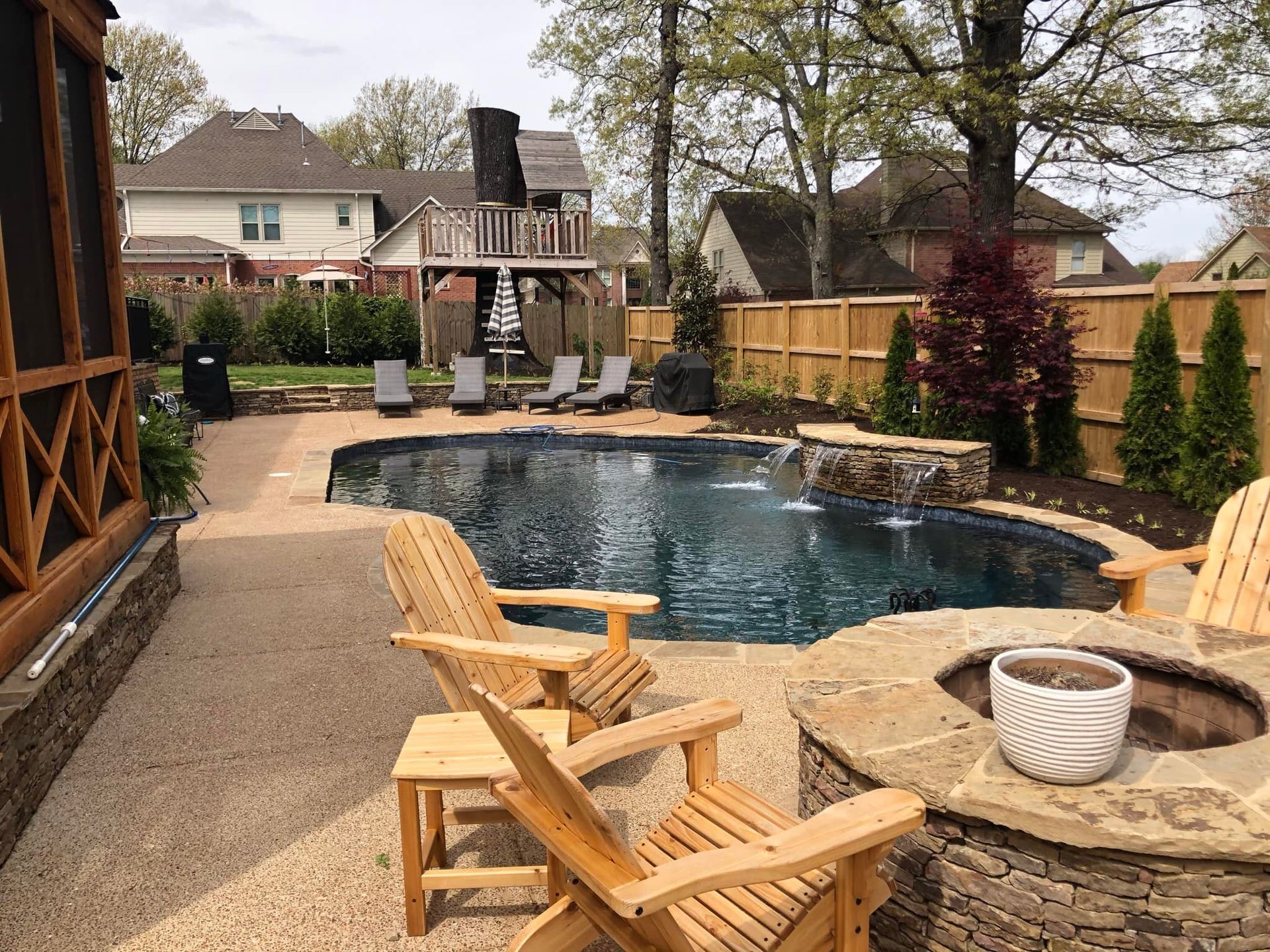 Backyard with pool, fire pit, lounge chairs, and wooden screened-in porch.