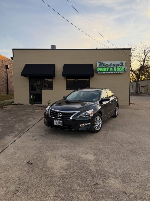Dark gray Nissan Altima parked in front of a tan building with black awnings; a neon sign reads "Big D's Mobile Body Shop".