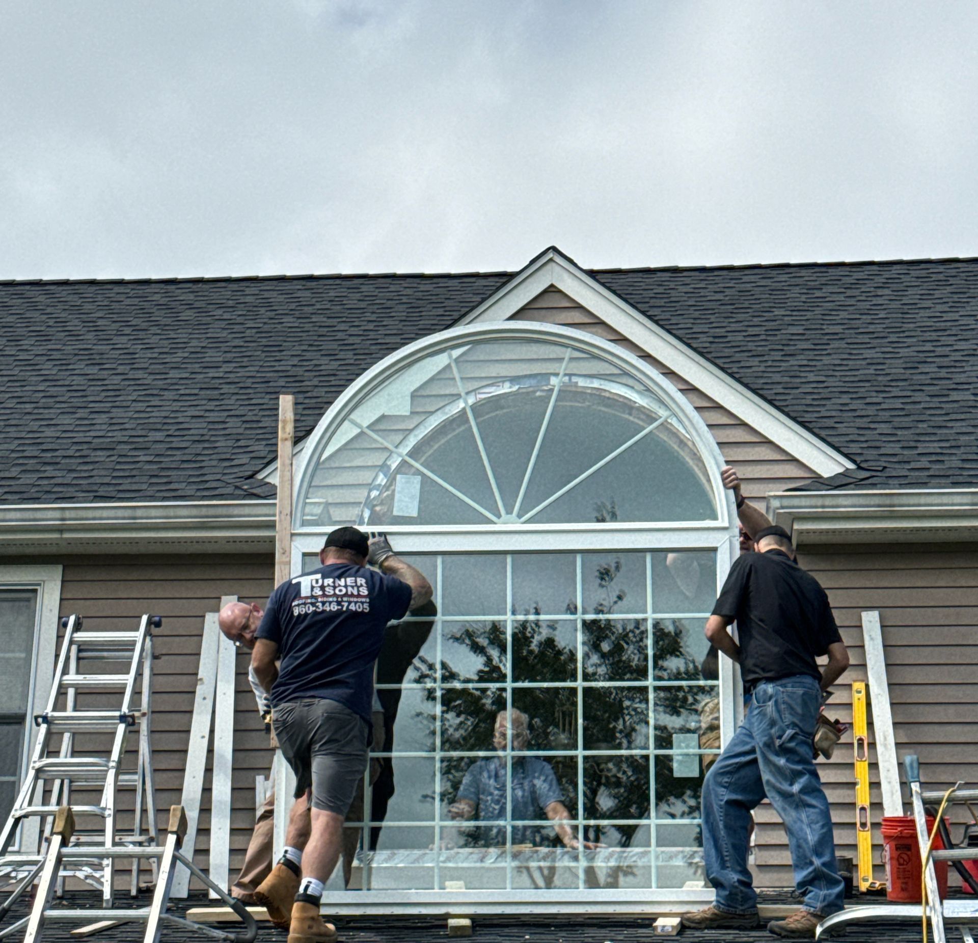 A group of men are installing a sliding glass door on a house.