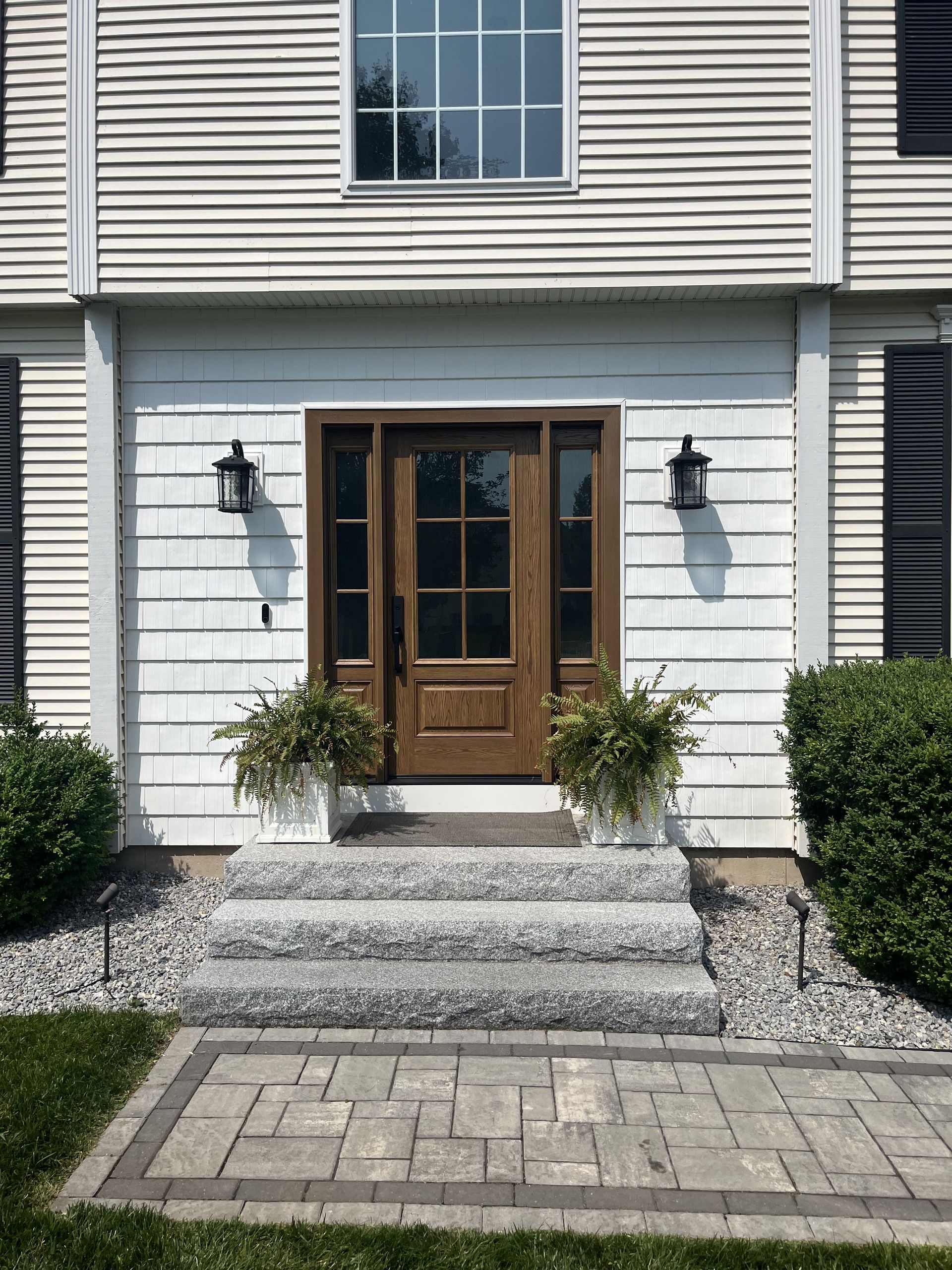 The front of a house with a wooden door and steps.