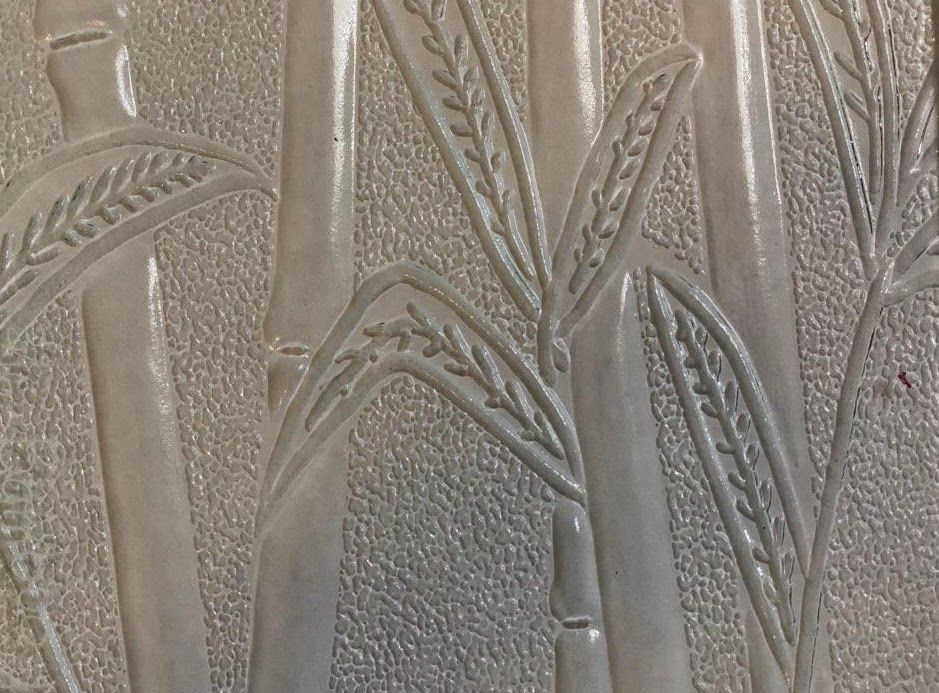 Embossed frosted glass with tall reeds and leaves in muted gray tones