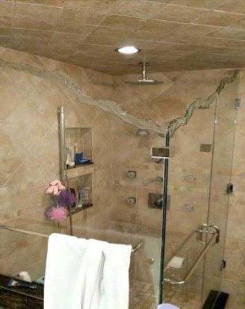 Tiled walk-in shower with glass door, built-in shelves, and a rain showerhead.
