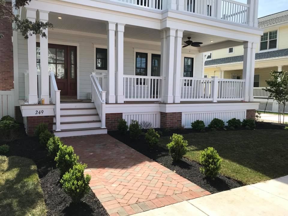 A white house with a large porch and stairs