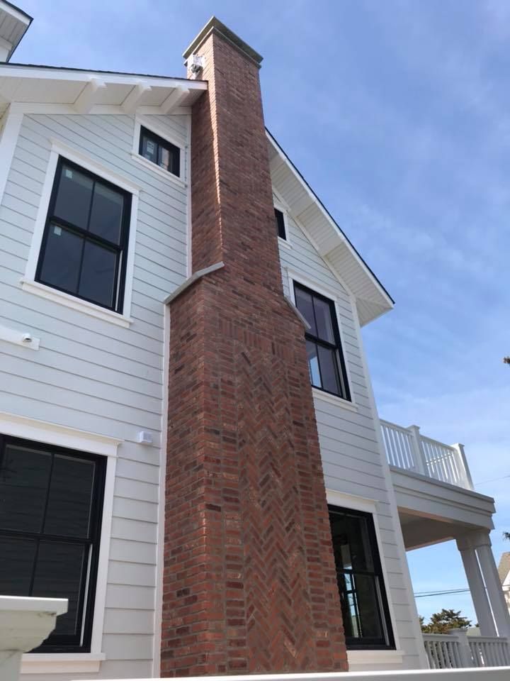 A white house with a brick chimney on the side