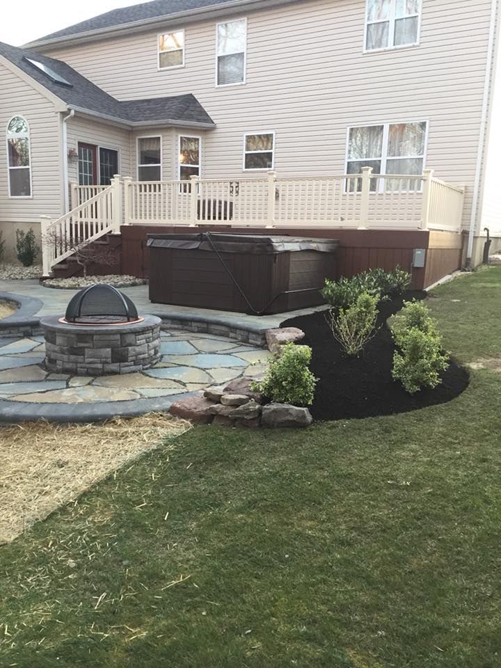 There is a hot tub on the deck of a house.