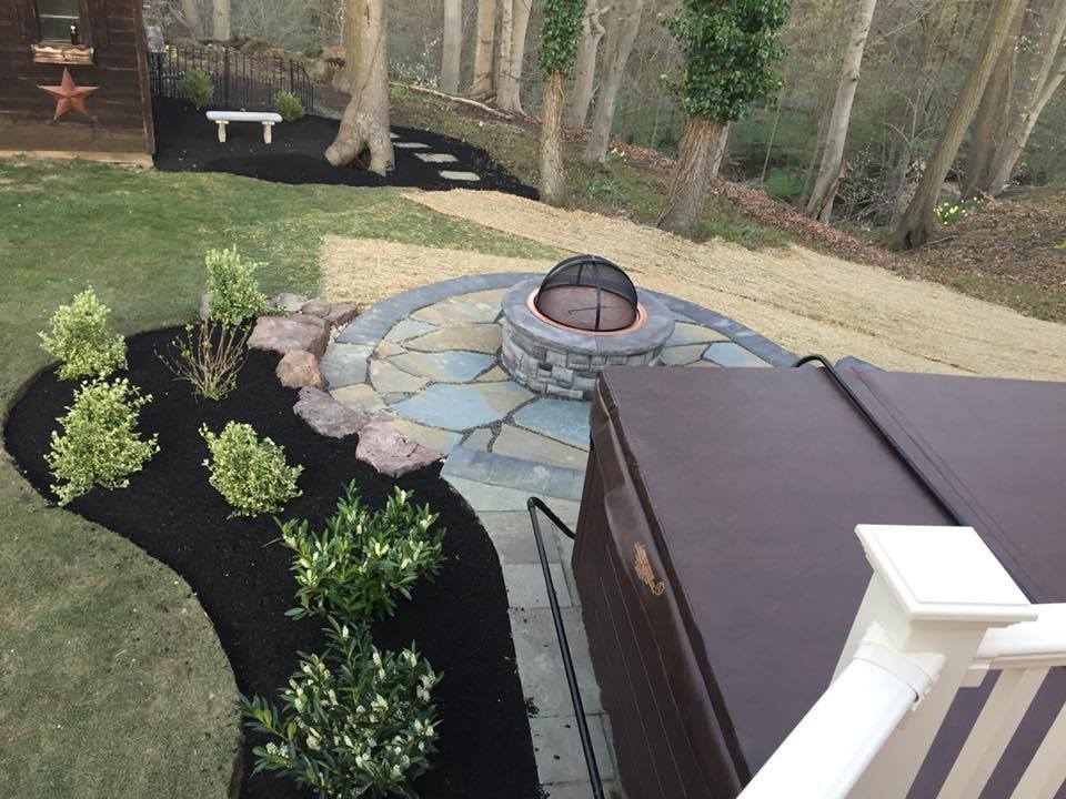 A backyard with a fire pit and a hot tub