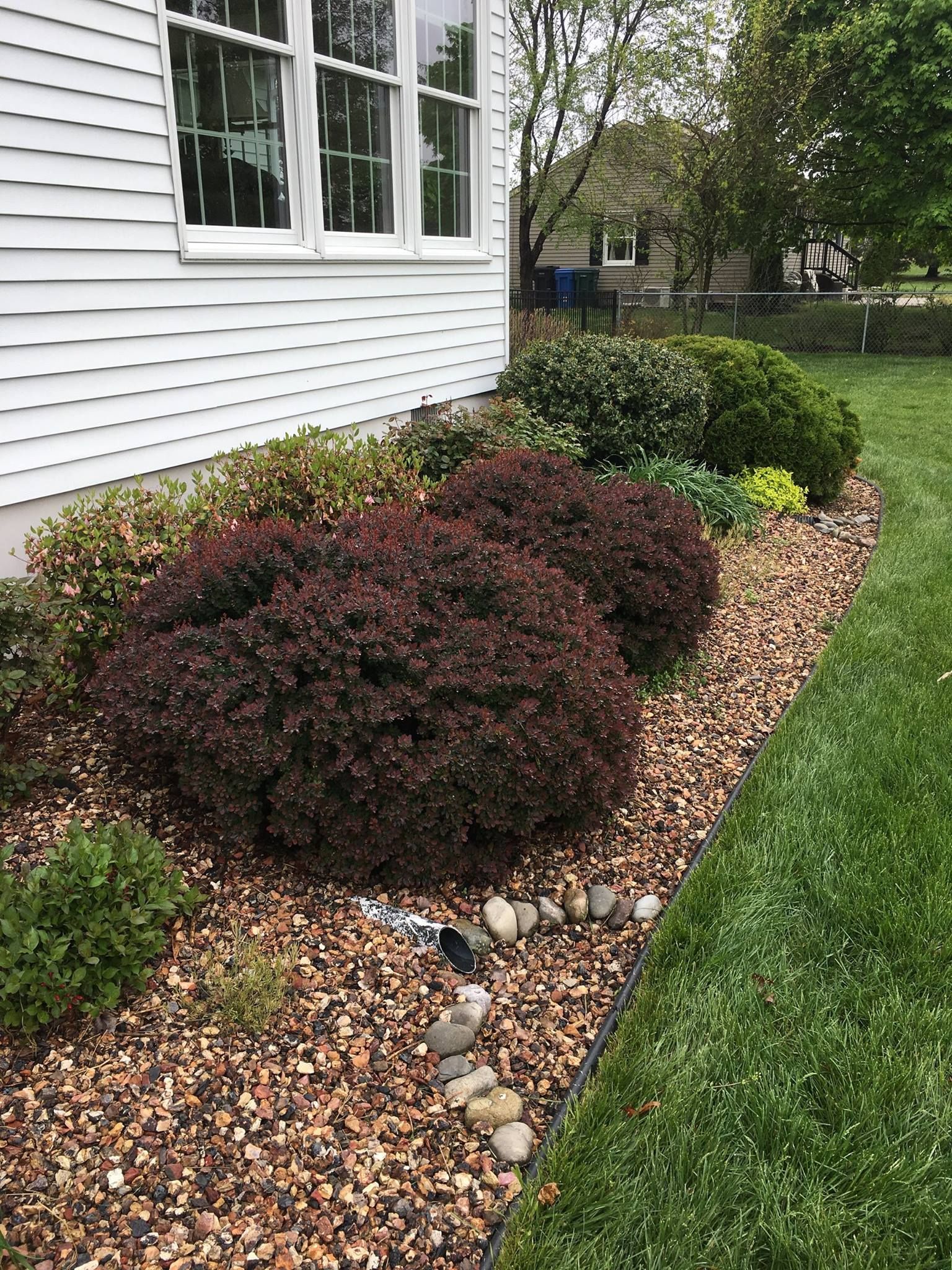 A white house with a garden in front of it.