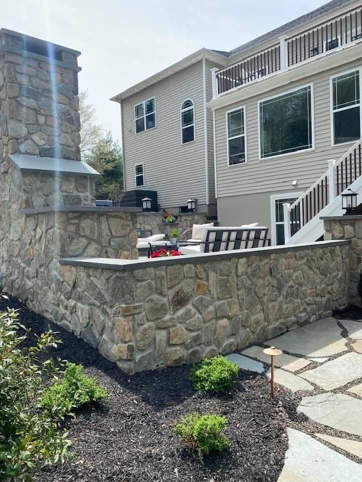 A large house with a stone wall in front of it.