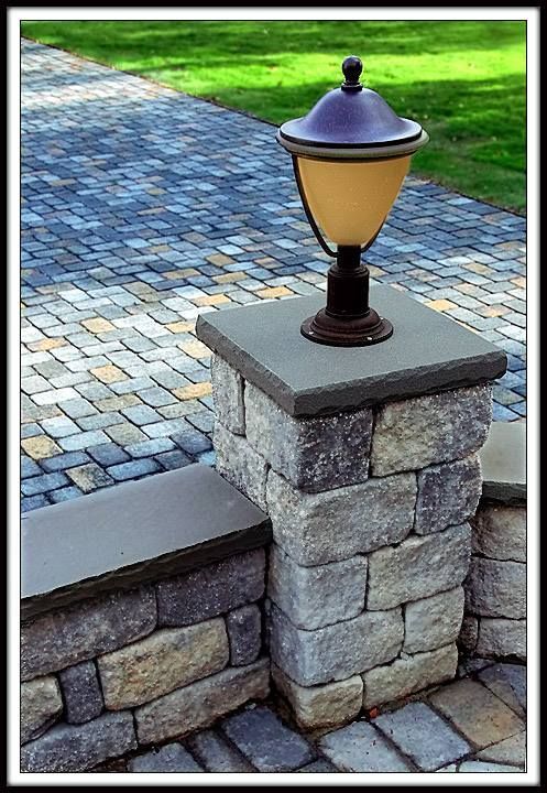 A lamp is sitting on top of a stone pillar.