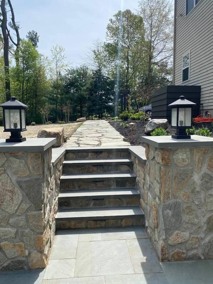 A stone walkway with stairs leading up to a house.