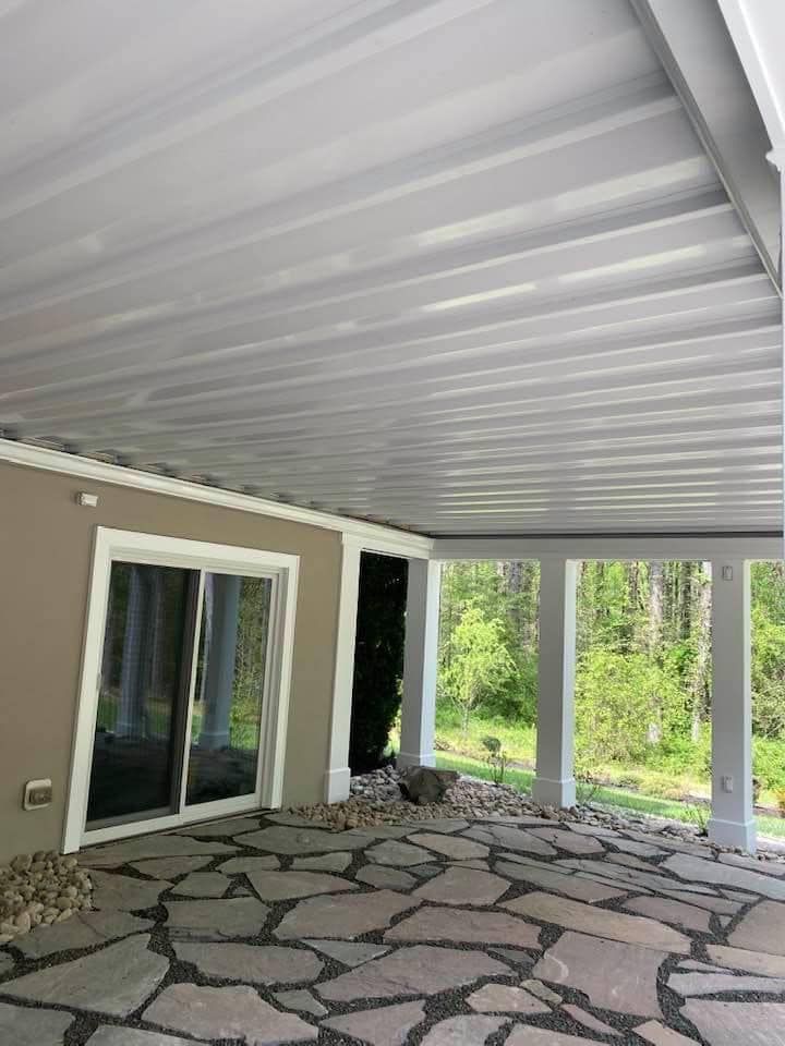 A porch with a metal roof and a stone floor.