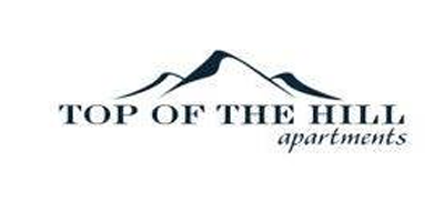 A logo for top of the hill apartments with a mountain in the background.