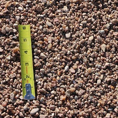 Tan and gray gravel with a yellow tape measure for scale.