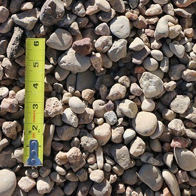 Gravel with various colors and sizes, next to a yellow ruler measuring up to 6 inches.