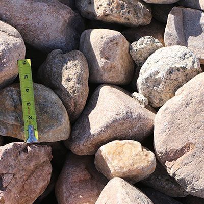 Pile of light brown and tan river rocks, with a ruler for scale.