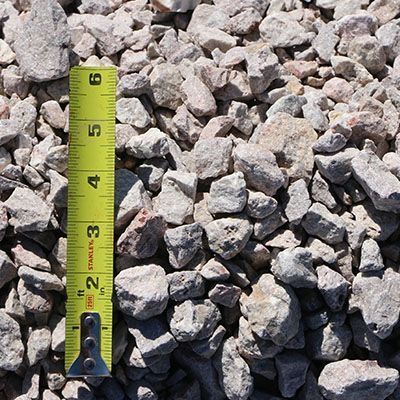 Gray gravel and a yellow tape measure.