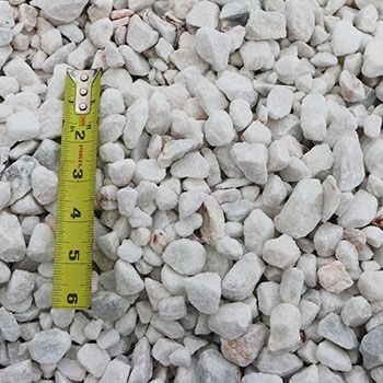 White gravel with a yellow and black measuring tape.