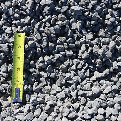 Gray crushed stone with a yellow tape measure, ranging from 1-5 inches.