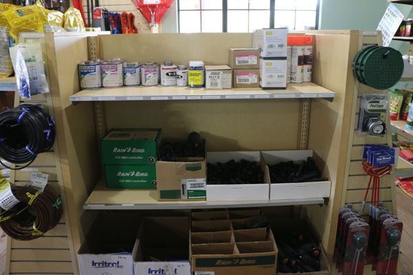Shelving display in hardware store: paint cans, boxes of fittings, and electrical cable.