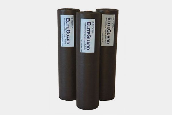 Three rolls of brown EliteGuard professional laminate underlayment with white labels.
