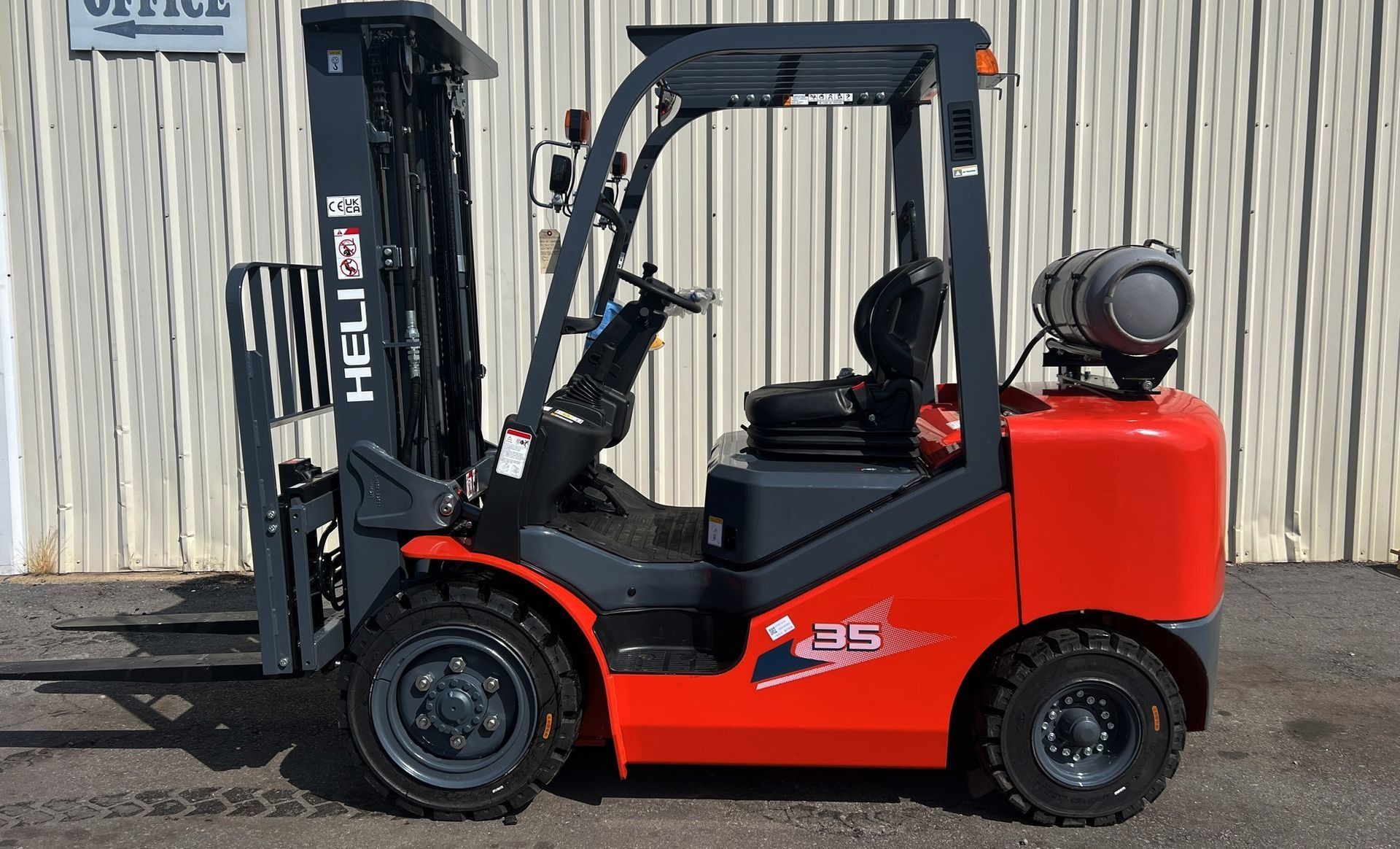 Red and gray HELI forklift truck parked outside.