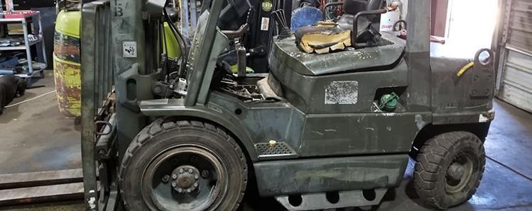 Olive green forklift in a warehouse.