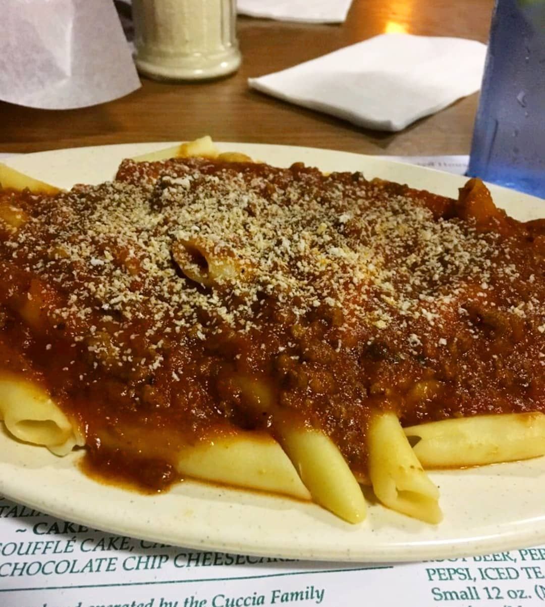 A plate of pasta with sauce and cheese on a table