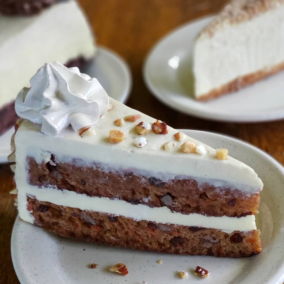 A slice of cake on a plate with whipped cream on top