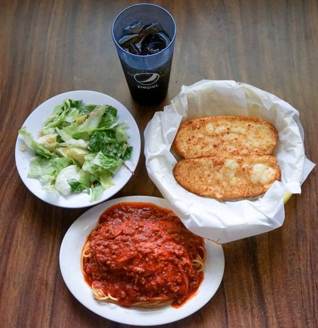 Three plates of food and a pepsi glass on a table