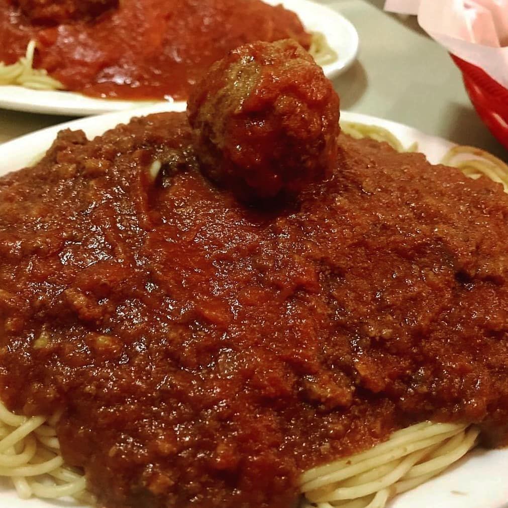 A plate of spaghetti with meatballs and sauce on top