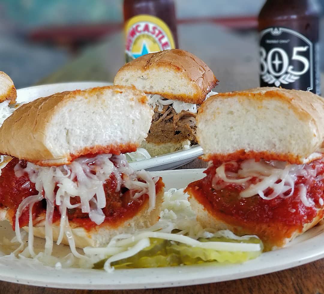 A plate of food with a bottle of beer in the background that says 305
