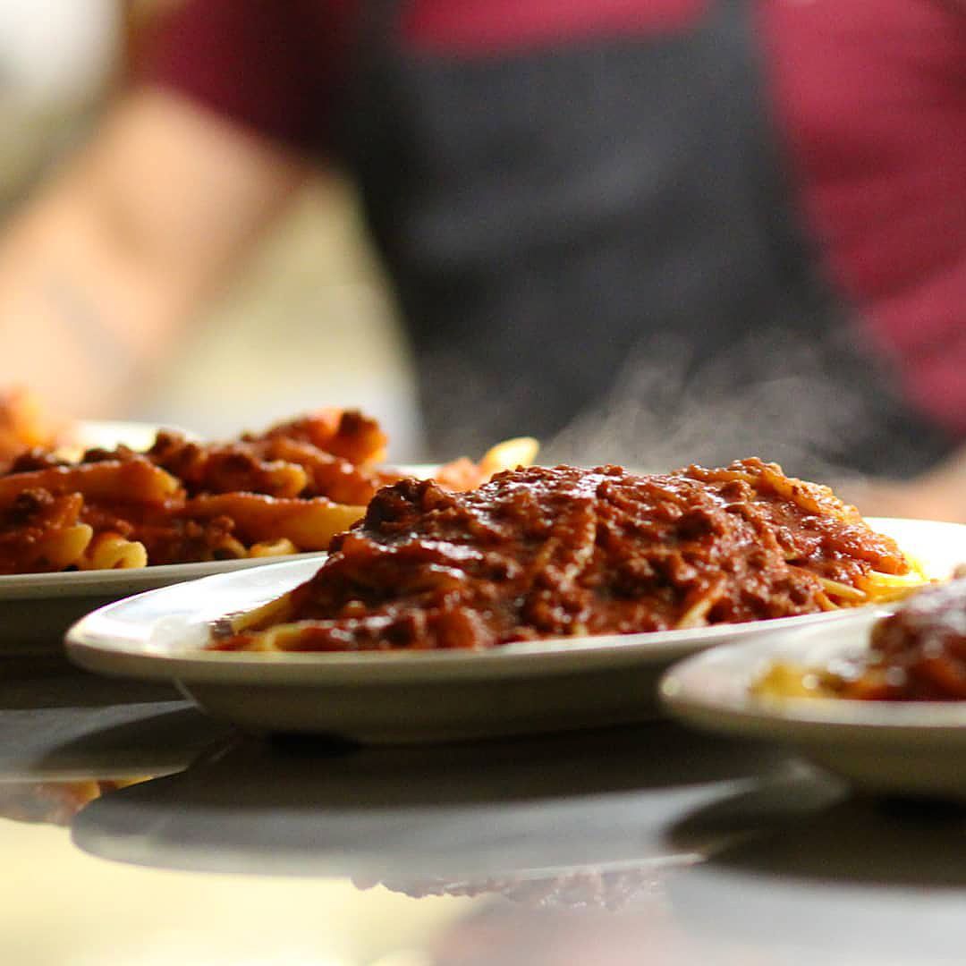 Plates of food on a table with a person in the background