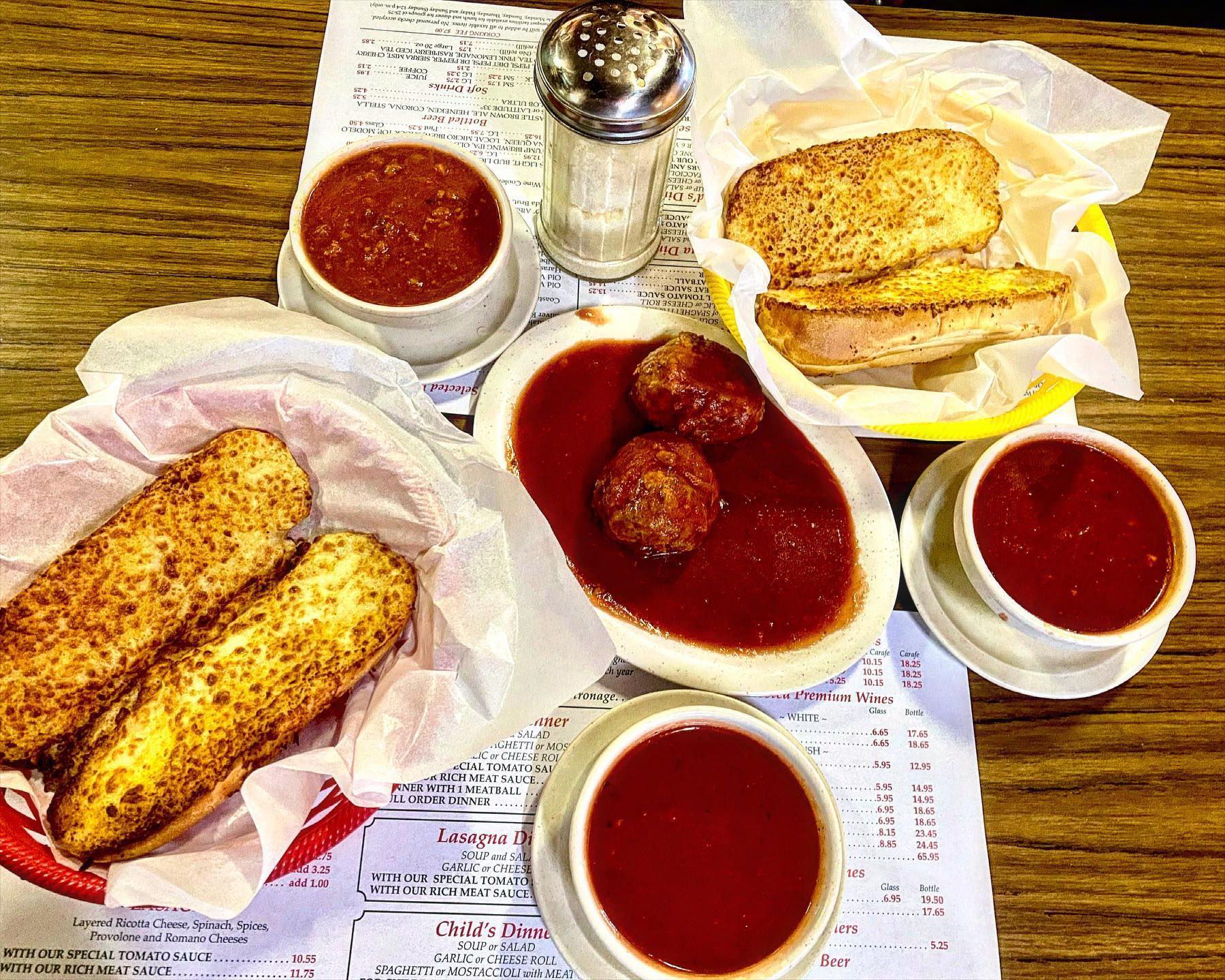 A table topped with plates of food and bowls of sauce