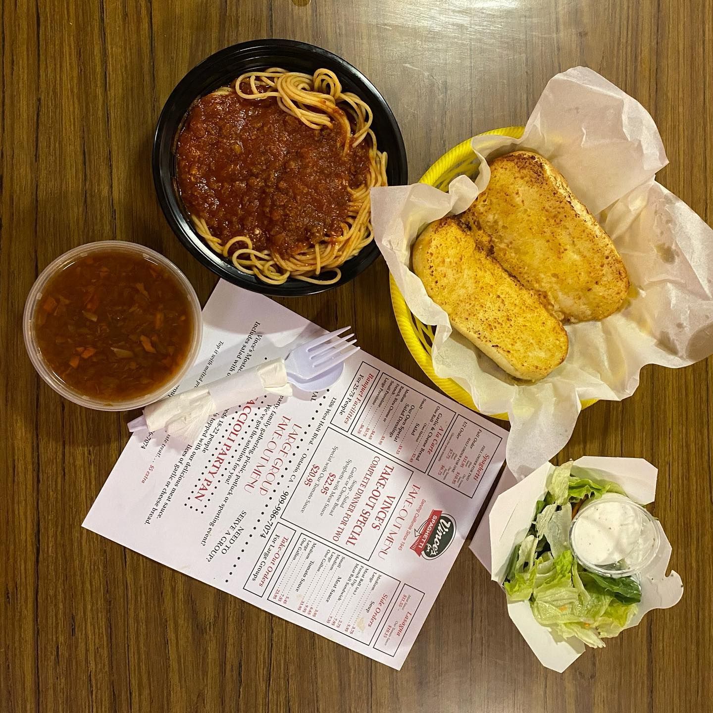 A table with a bowl of spaghetti and a basket of mozzarella sticks