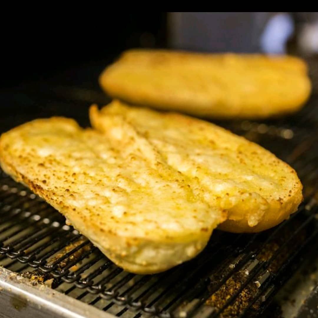 Two pieces of bread are cooking on a grill