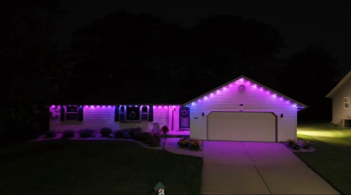 A house with purple lights on it at night.