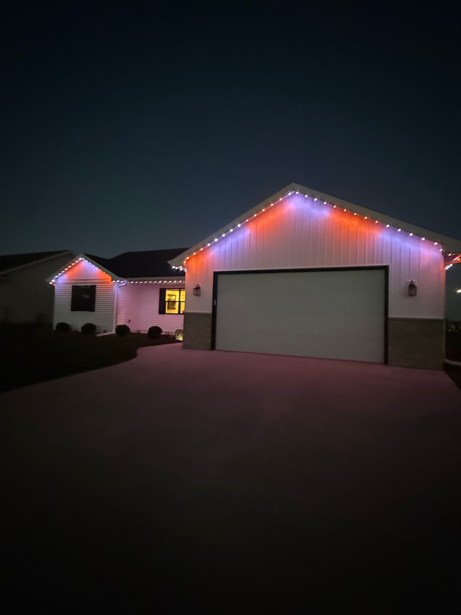 House decorated with blue Christmas lights at night.