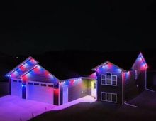 A house is decorated with christmas lights and trees