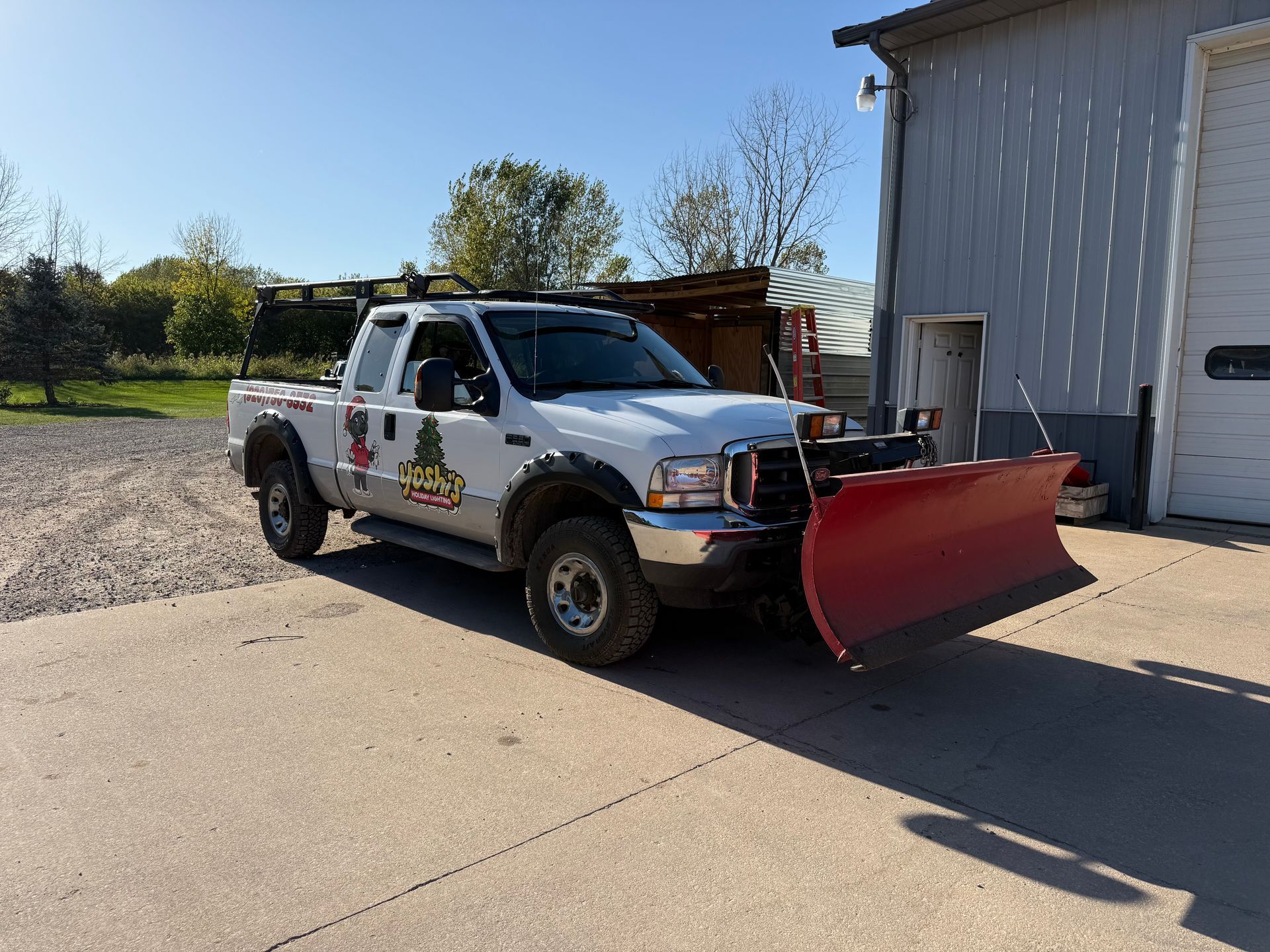 A yellow snow plow is plowing snow in a parking lot