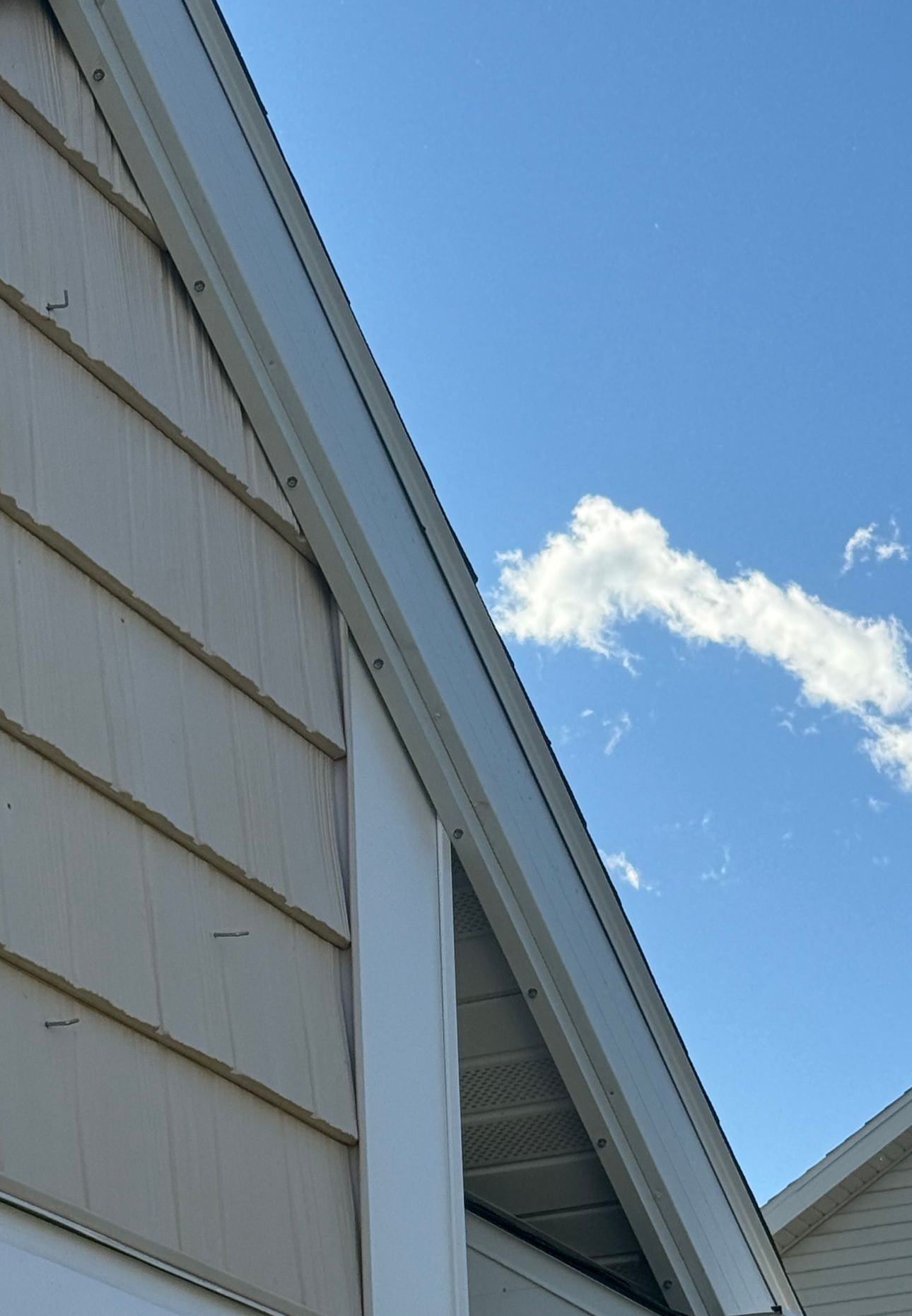 House at night with Christmas lights outlining roof and trees, snow-covered ground.